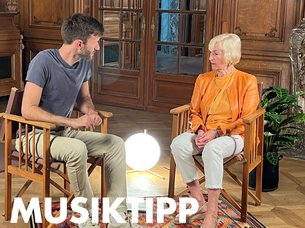 Two people sit and talk