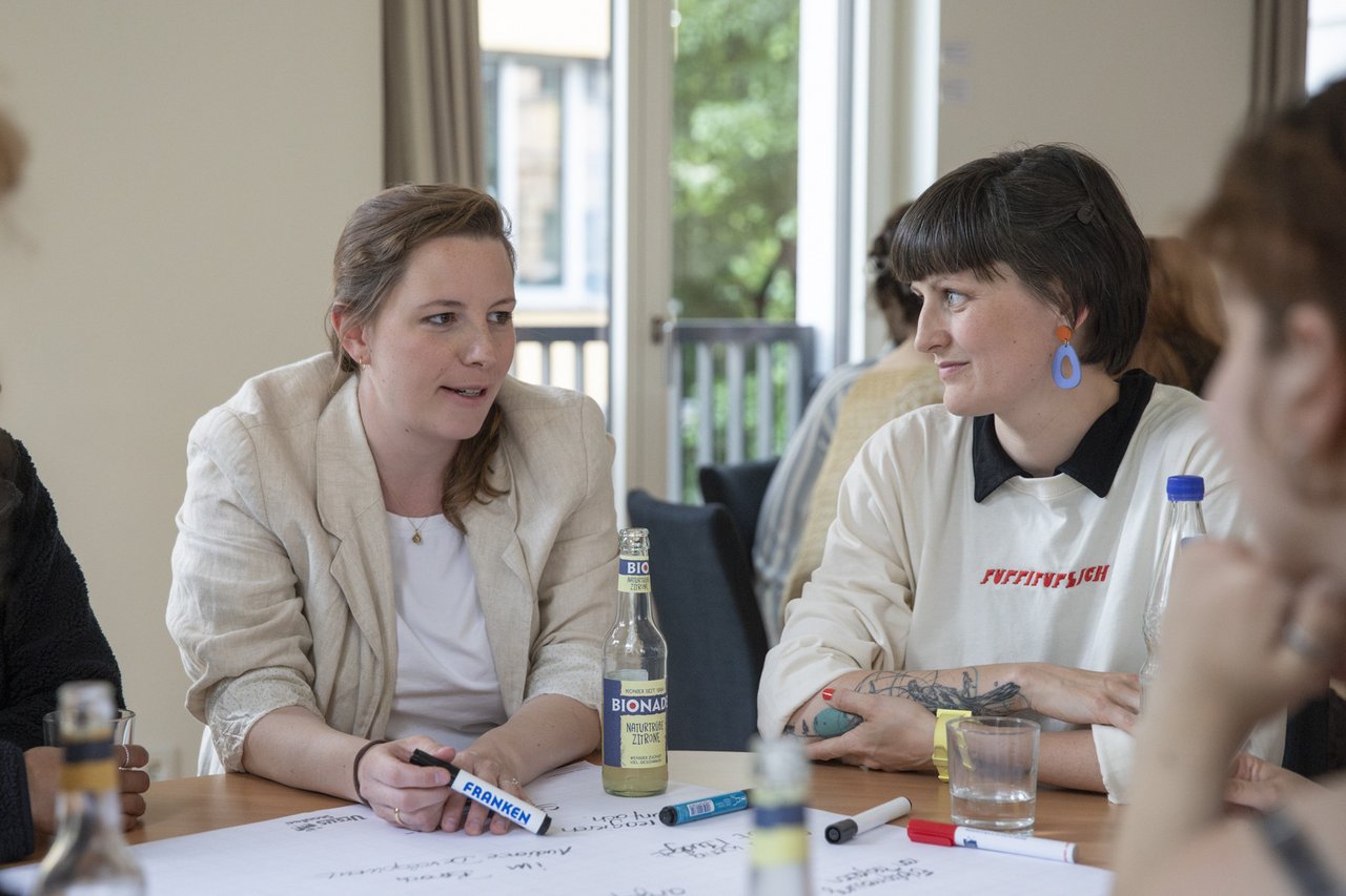 Zwei Studierende in zwangslosem Tischgespräch