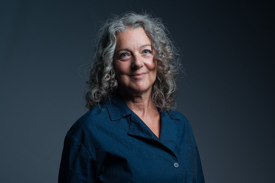 Foto einer lächelnden Frau mit langen, lockigen Haaren