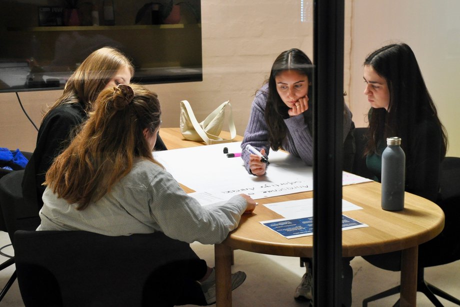 Four students talking at one table