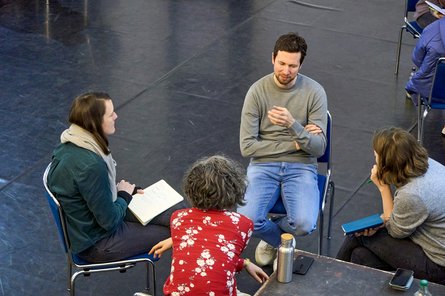 Vier Studierende sitzen im Kreis auf Stühlen und unterhalten sich