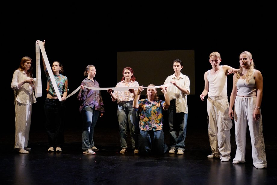 A group stands in a row and passes on an object.