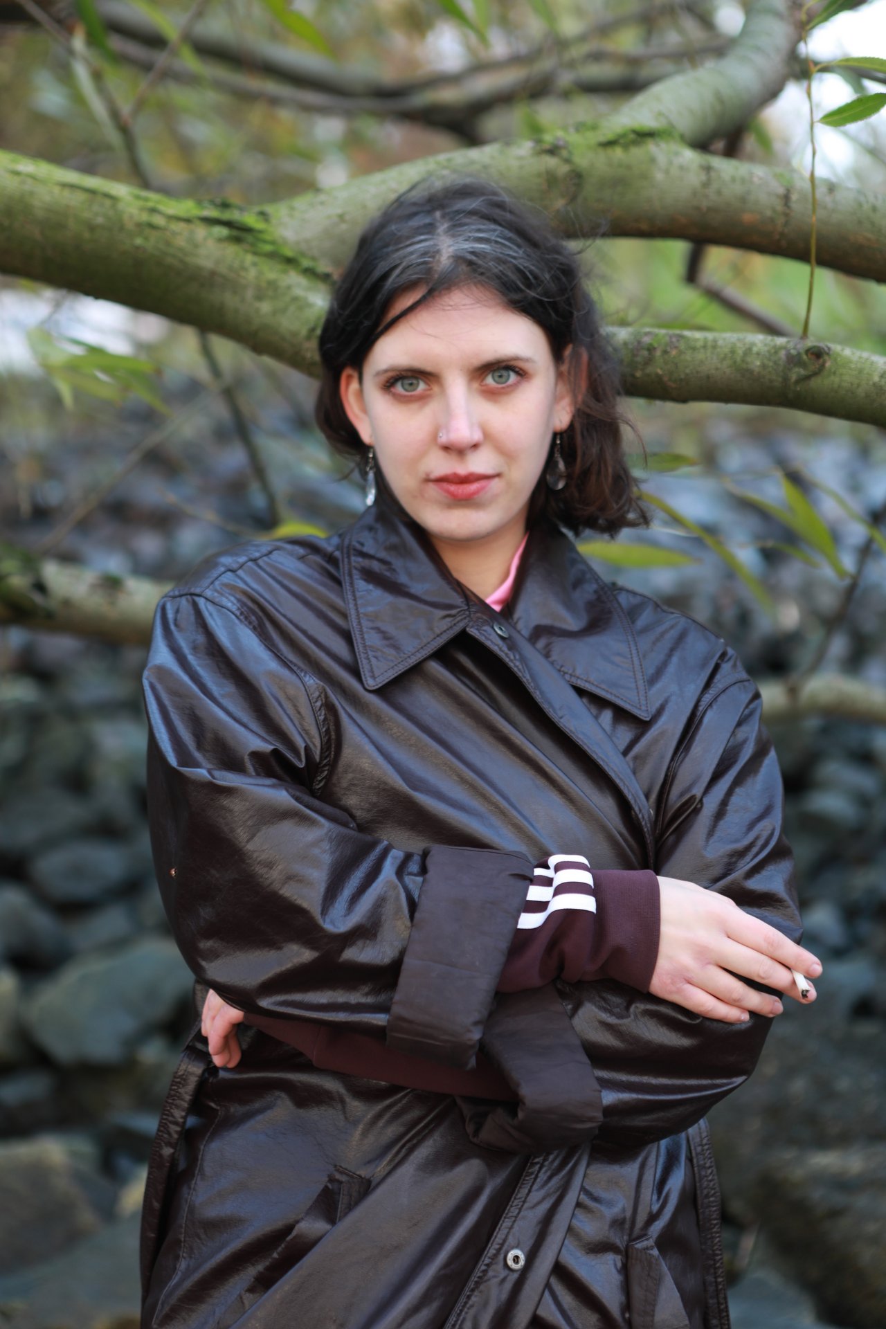 Portrait photo of Musa Kohlschmidt in front of a branch and stones.