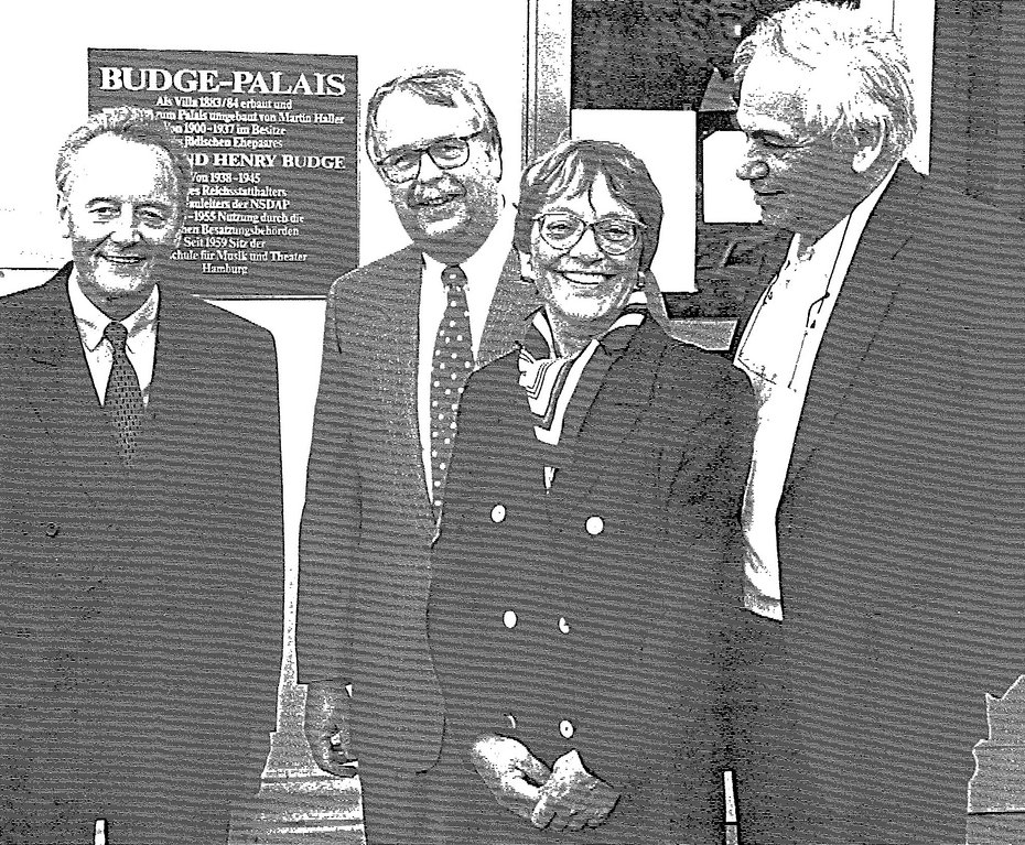 4 People in front of the memorial plaque for the Budge couple in front of the entrance to the HfMT