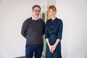 Frau und Mann stehen vor einer Säule