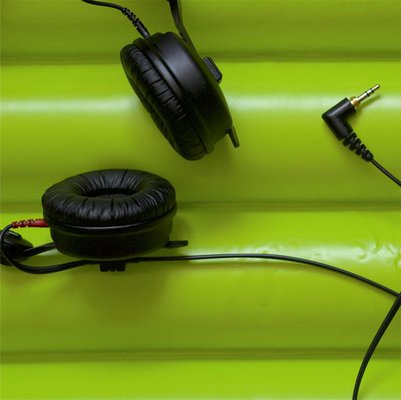 Headphones against a green background