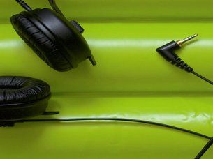 Headphones against a green background