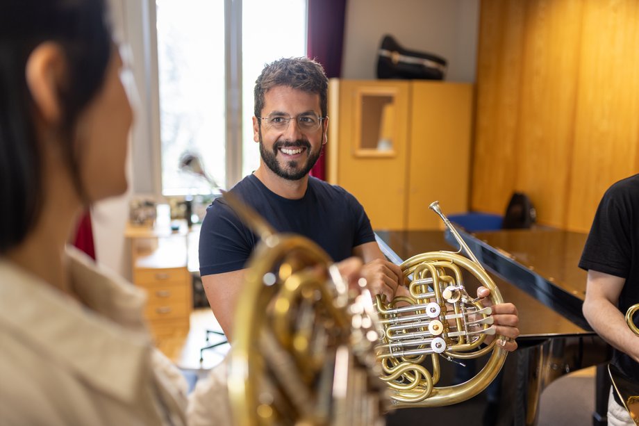 3 Personen mit Horn in der Hand in Kommunikation miteinander