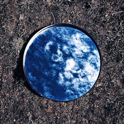 The sky is reflected in a bowl of water on the earth