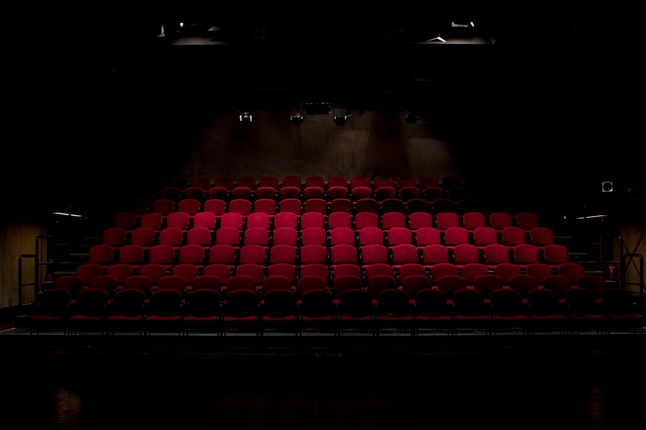 Blick auf rote, leere Theatersessel in einem Theatersaal