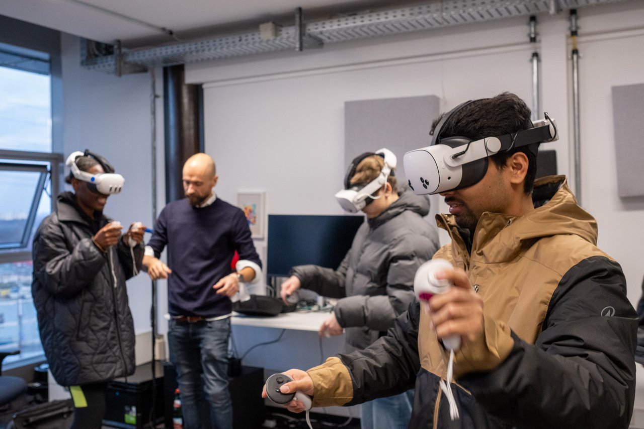 Vier Personen in einem Raum, drei davon mit VR-Brillen