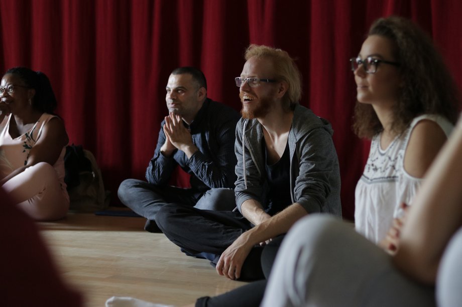 Four participants listen and watch.