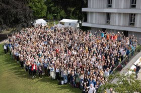Eine sehr große Gruppe von Menschen auf dem Rasen vor der HfMT
