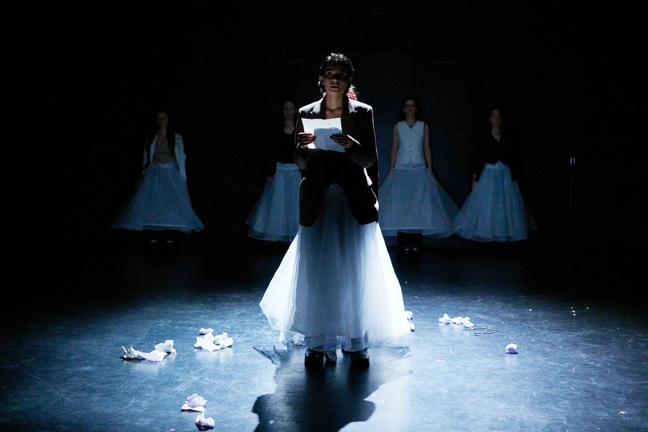 The actress stands in the beam of light and reads a letter.