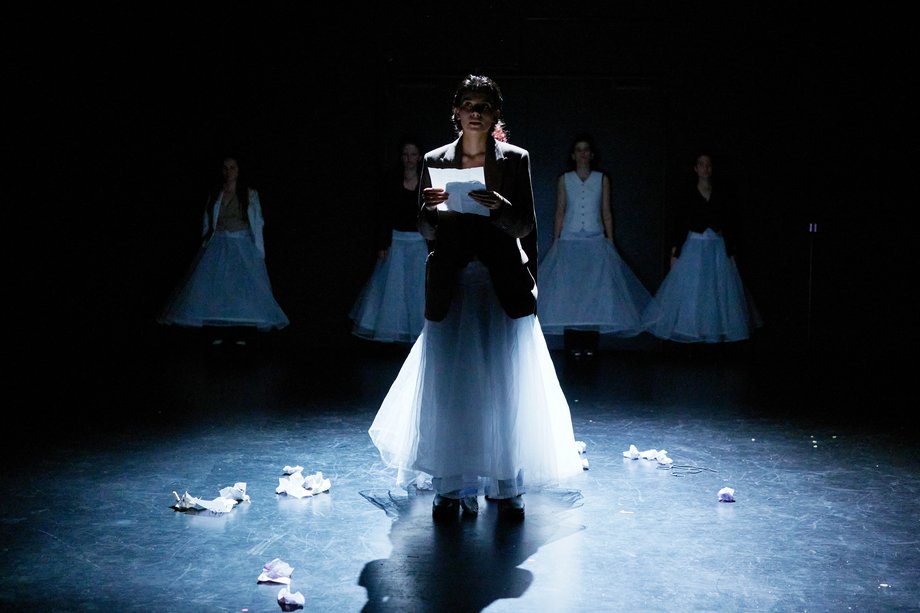 The actress stands in the beam of light and reads a letter.